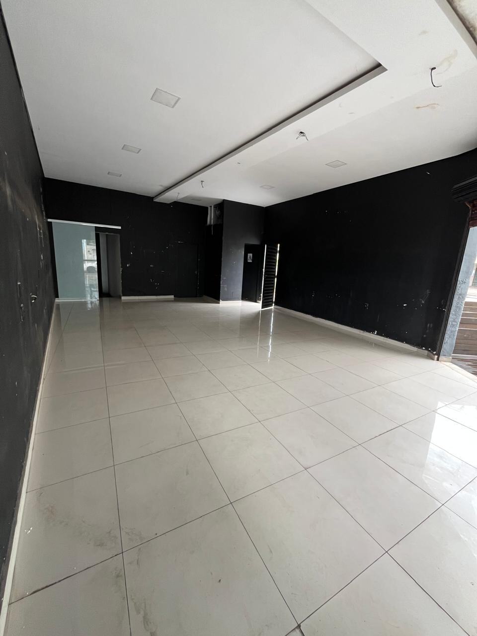 Vista longitudinal do salão comercial mostrando a profundidade do espaço